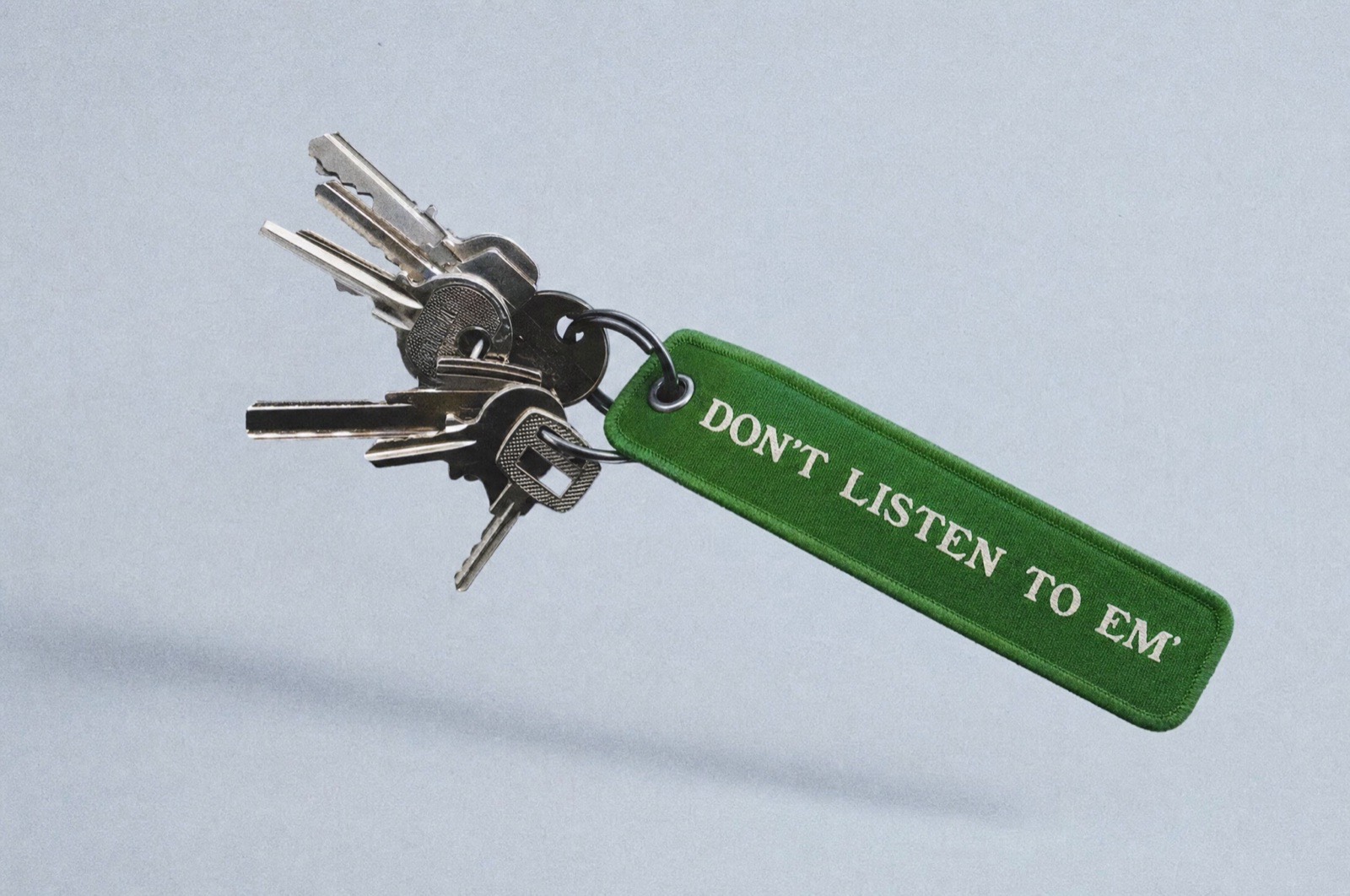 Keychain stamped with the Conspiracy Board Shop mark and Don't Listen To Em'